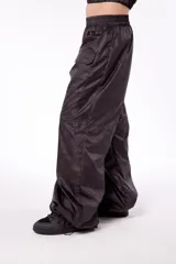 Pantalón wide leg impermeable negro con estampado de logos. Tiene bolsillos laterales ocultos, bolsillos en piernas y en posterior. Tiene tanca en ruedo para ajustar.