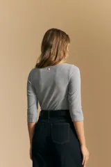 Remera de tejido acanalado (rib) color blanco, con escote cuadrado y mangas tres cuartos, de ajuste entallado al cuerpo.