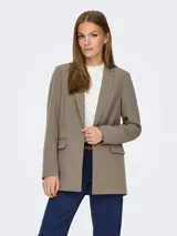 Blazer largo de corte holgado con solapas clásicas y bolsillos delanteros con solapa. Confeccionado en una mezcla de poliéster reciclado y elastano.