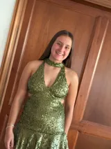 Vestido corto de fiesta totalmente cubierto de lentejuelas doradas, con escote halter profundo, cuello tipo gargantilla integrado y falda con volado en el ruedo.