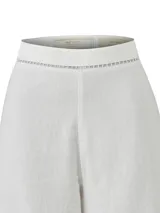 Pantalon de lino organico y viscosa de corte recto y tiro alto, color blanco, con detalles de calados geometricos en la cintura y en los dobladillos.