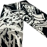 Bufanda de tejido de punto con diseño abstracto de ondas en colores blanco, gris y negro.
