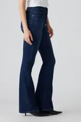 Jean de corte flare con tiro alto, confeccionado en denim azul oscuro con efecto desgastado. Presenta cierre de cremallera con botón metálico, cinco bolsillos tradicionales y costuras reforzadas.