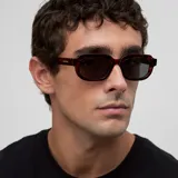 Lentes de sol con montura rectangular de diseño clásico con bordes redondeados en estampado carey y cristales polarizados color negro.