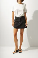 Minifalda de jean color negro con lavado gastado, corte recto y tiro alto.
