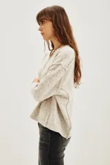 Sweater amarillo de calce relajado, mangas largas, cuello redondo y hombros caídos.