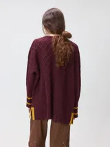 Sweater de cuello redondo con diseño de tejido en relieve de rombos, manga larga y calce holgado. Presenta logo bordado en el pecho y aberturas laterales en el ruedo.