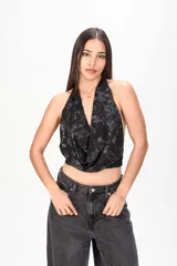 Top halter negro con diseño estampado y escote drapeado.