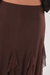 Pollera larga color chocolate confeccionada en microtul, totalmente forrada, con diseño fluido y volados en cascada que aportan movimiento.