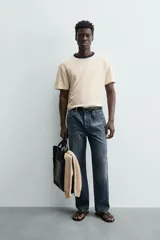 Camiseta de manga corta y cuello redondo, color azul marino, con ribete de contraste en color crema alrededor del cuello.