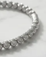 Pulsera esclava de acero compuesta por pequeñas esferas texturizadas con un diseño estriado.