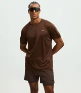 Remera deportiva de manga corta y cuello redondo, confeccionada en tejido de malla de poliéster. Presenta un diseño liso en color marrón con recortes laterales en poliamida.