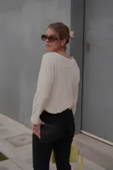 Buzo negro de punto con cuello redondo y logo bordado en el pecho.