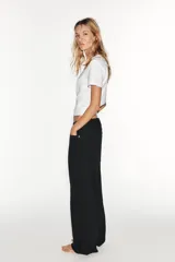 Jeans de tiro medio estilo balloon en color negro, con diseño de cinco bolsillos, trabillas para cinturón y cierre frontal con cremallera y botón metálico.