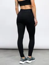 Calza deportiva Umbro modelo Legging Bink para mujer, de color negro, con cintura alta cruzada y elástica con la marca estampada.