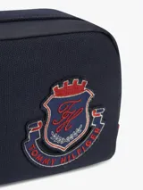 Cartera tipo camera bag Tommy Hilfiger de color azul marino, con compartimento principal con cierre, correa ajustable y desmontable, y parche con el logo de escudo de la marca bordado en el frente.