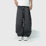 Pantalón de jean estilo ultra baggy, color negro lavado, con diseño de paneles curvos y costuras reforzadas en las piernas. Presenta un corte extremadamente holgado y tiro medio.
