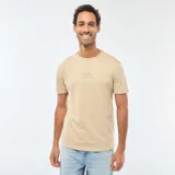 Remera beige de manga corta y cuello redondo, con pequeño estampado circular en el centro del pecho que incluye texto en tonos rosados y blancos.