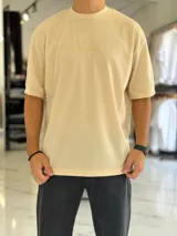 Remera oversize de tejido waffle color beige, con cuello redondo y mangas cortas.