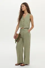 Pantalón de lino color beige, de corte ancho y relajado, con cintura alta y bolsillos laterales.