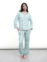 Conjunto de pijama de dos piezas, color verde menta con estampado de cuadros irregulares en blanco. Incluye camisa de manga larga con botones y pantalón largo con cintura elástica.