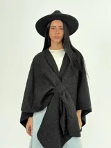 Ruana color crema confeccionada en lana italiana con textura tipo "corderito". Se puede usar abierta o cerrada.