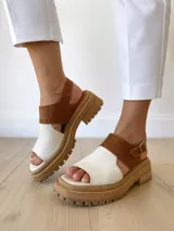Sandalias de cuero color camel y crudo, con plataforma track y hebilla ajustable.
