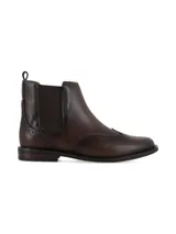 Bota tipo Chelsea de cuero color marrón chocolate, con diseño brogue en la puntera y el talón, elásticos laterales y suela plana con pequeño tacón.