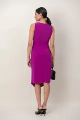 Vestido midi al cuerpo de color fucsia, con escote cruzado en V, sin mangas y falda asimétrica con detalle de drapeado frontal.