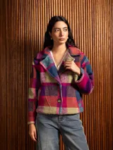 Chaquetón corto de lana con diseño a cuadros en tonos fucsia, azul y verde. Presenta solapas amplias y cierre frontal con botones.