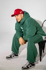 Pantalón de jogging verde oscuro con corte holgado, cintura elástica con cordón de ajuste y bolsillos laterales.
