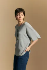 Remera de calce relajado con silueta fluida, confeccionada en tejido de viscosa con elastano. Presenta cuello redondo, mangas cortas y un diseño minimalista de caída suave.