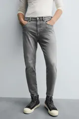 Jeans de hombre, corte skinny y largo cropped, color negro lavado. Presenta cinco bolsillos y cierre frontal con cremallera y botón.