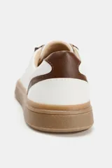 Zapatillas deportivas de color blanco con detalles en marrón y suela de goma color tostado. Cierre con cordones y puntera redonda.