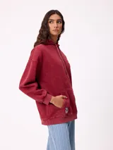 Canguro oversize color negro con efecto lavado, capucha y estampa gráfica en la espalda con tipografía desgastada y detalles en color turquesa.