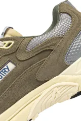 Championes urbanos Autry modelo Hyperway Low, color verde oliva con detalles en gris y crema. Confeccionados en una combinación de gamuza y malla técnica, presentan el logo de la marca en el lateral y una suela con tecnología Action Cush.