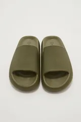 Sandalias de goma color verde oliva, estilo slide, con suela gruesa y plataforma texturizada.