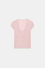 Top rosado de manga corta con escote redondo y diseño simulando un doble efecto con top interior y lazo decorativo en el pecho, además de cierre frontal con botones.