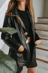 Blazer de cuero dorado metalizado, con bolsillos frontales aplicados, solapas clásicas y cierre con grandes botones de nácar.