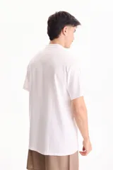 Camisa de lino de manga corta, color blanco, con cuello mao y cierre frontal de botones.