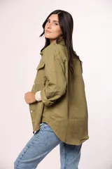 Camisa de pana fina color beige, con cuello clásico, cierre frontal de botones y dos bolsillos con solapa en el pecho.