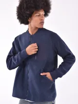 Campera gris claro de corte bomber, con cuello, puños y ruedo acanalados. Presenta cierre frontal y bolsillo en el pecho con cierre.