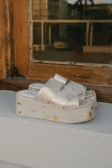 Sandalias con plataforma color dorado, con tiras cruzadas sobre el empeine y suela de goma.