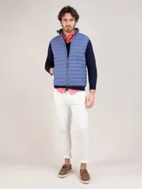 Chaleco acolchado de hombre color celeste, confeccionado en nylon reciclado con diseño matelasse, cuello alto y cierre frontal de cremallera.