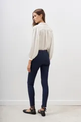 Jean ajustado de tiro alto, color azul oscuro, con acabado satinado.