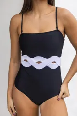 Traje de baño entero negro con breteles finos y detalle de recorte con forma de ondas en la cintura.