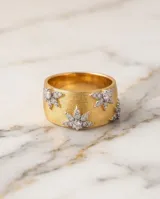Anillo ancho de bronce con baño de oro, acabado texturizado tipo malla y detalles de estrellas incrustadas con circonias.