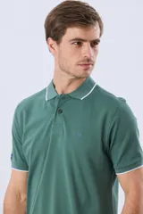 Remera polo de piqué azul marino, con cuello y puños de mangas cortas con ribete blanco en contraste, cierre frontal de dos botones y pequeño logo bordado en el pecho.