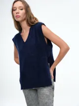 Chaleco tejido sin mangas con escote en V, confeccionado en cashmere con textura suave y diseño de líneas simples.