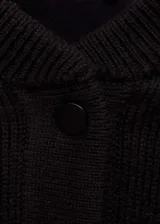Chaqueta estilo bomber de tejido de punto en color negro, con cuello redondo, cierre frontal de botones y detalles de rayas blancas en contraste en los hombros y puños.